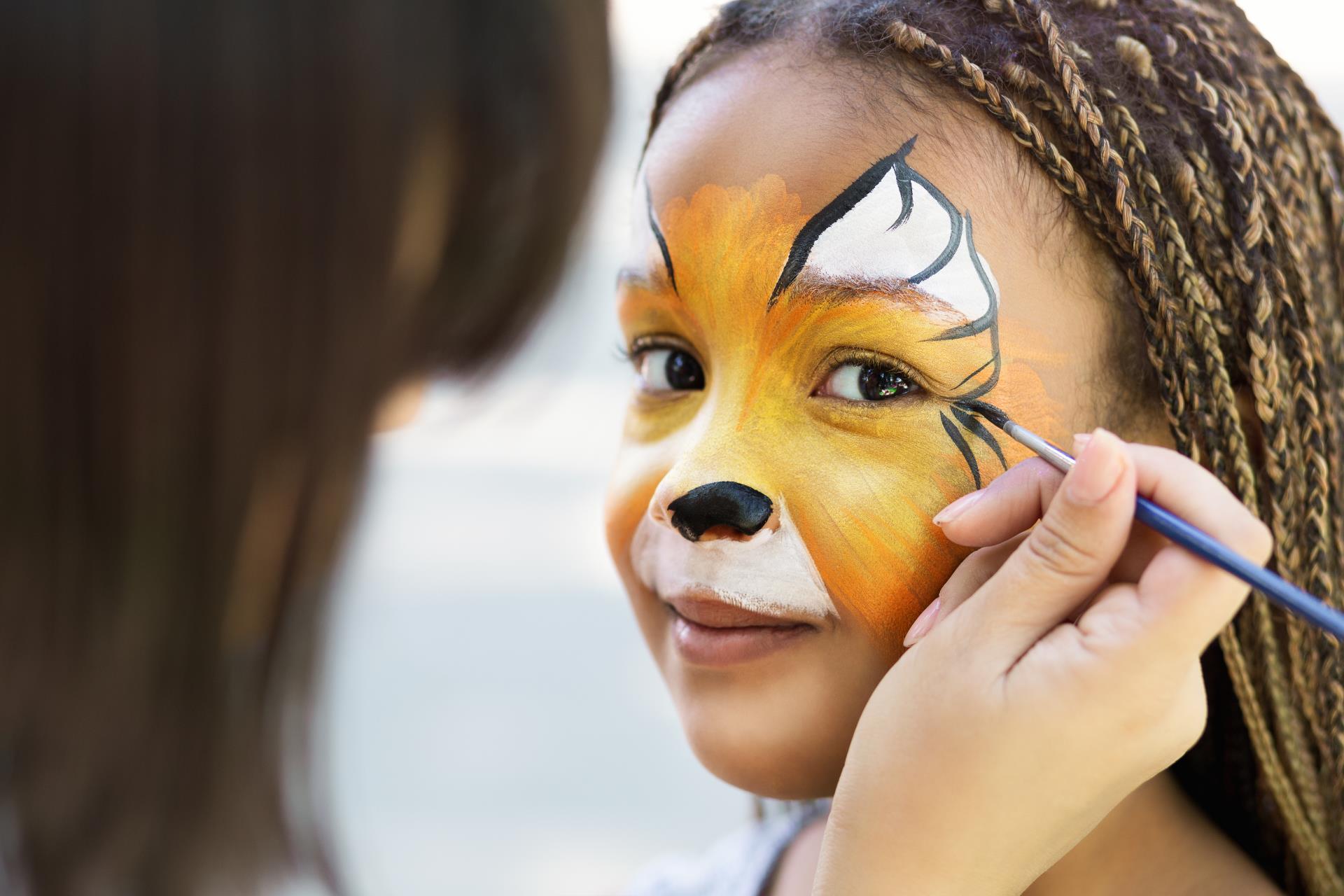 child having face painted like a tiger