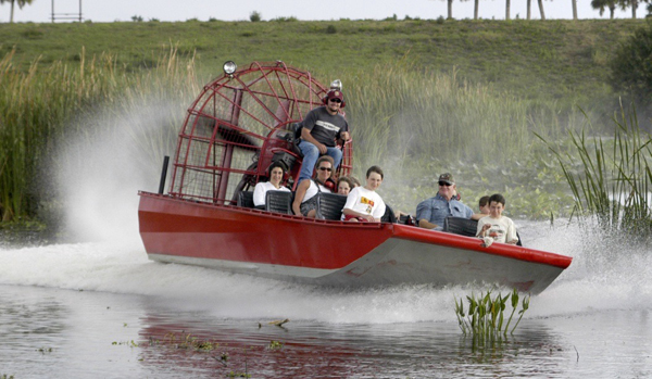 airboat operator with passengers on red airboat